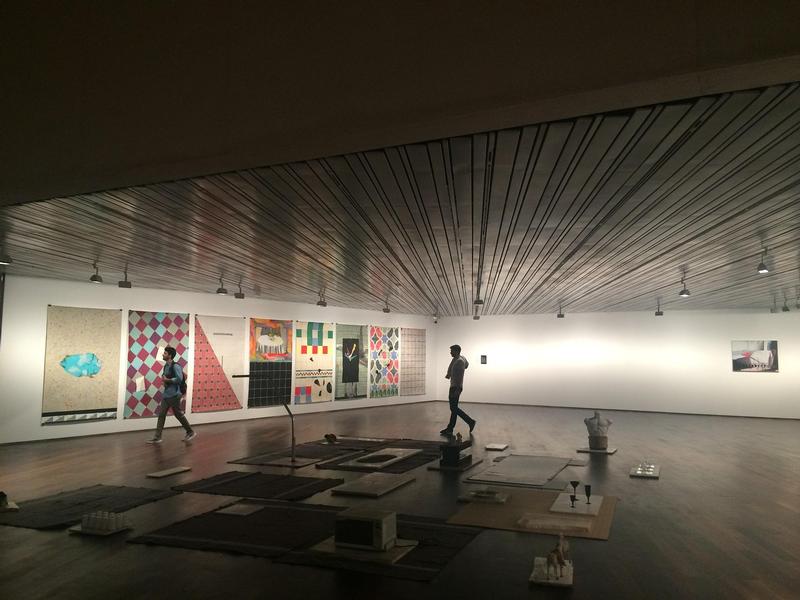 Hier sehen Sie zwei Besucher in einem dunklen Ausstellungsraum